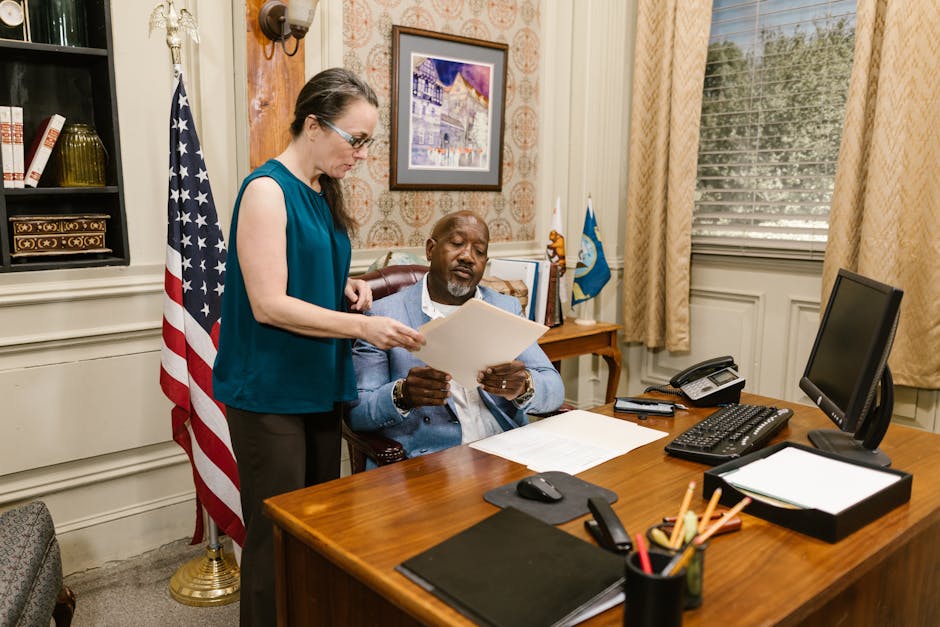 A lawyer and client discuss legal documents in a law office setting