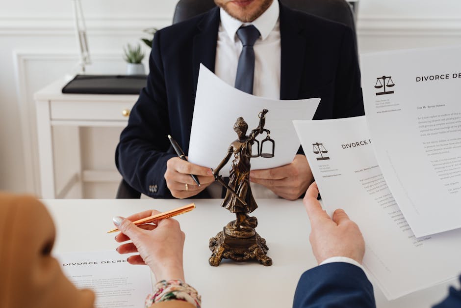 Legal professionals reviewing divorce documents in a law office with a Lady Justice statue